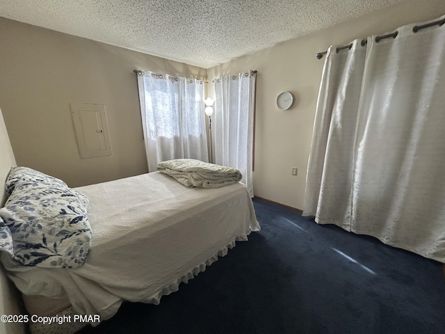 bedroom with a textured ceiling and dark colored carpet