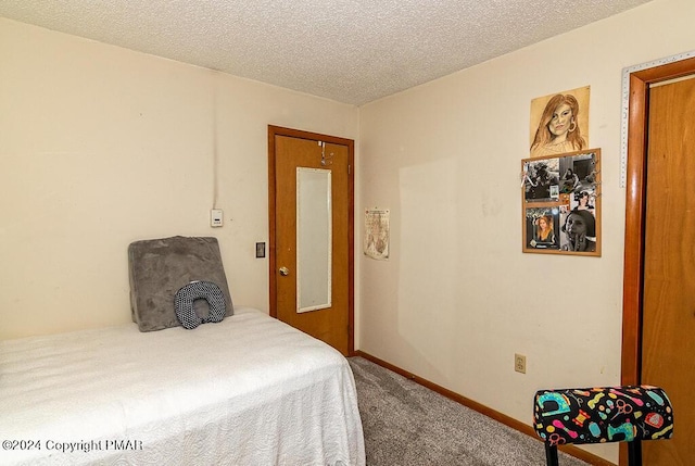 bedroom featuring baseboards, a textured ceiling, and carpet