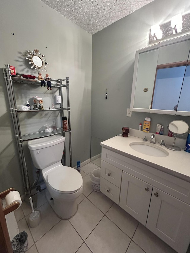 bathroom with tile patterned flooring, a textured ceiling, vanity, and toilet