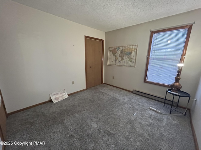 carpeted empty room featuring baseboards and a textured ceiling