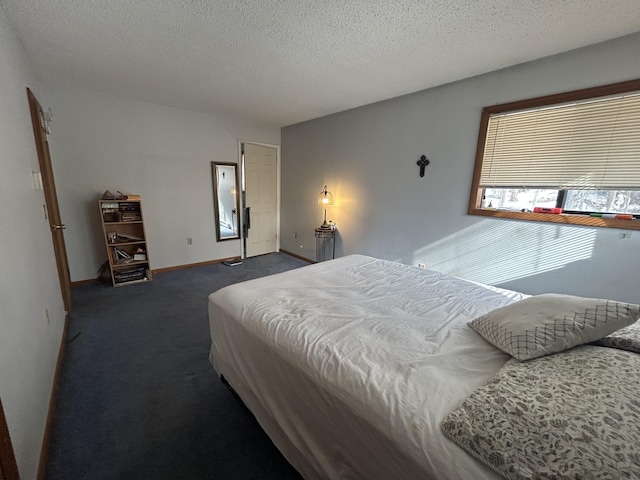 bedroom featuring baseboards, a textured ceiling, and dark carpet