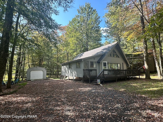 view of front of property with a garage, a wooden deck, and an outdoor structure