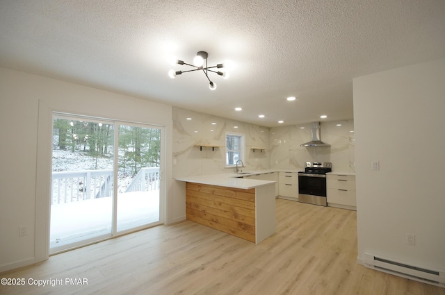 kitchen with a baseboard radiator, a peninsula, white cabinetry, light countertops, and stainless steel range with electric stovetop