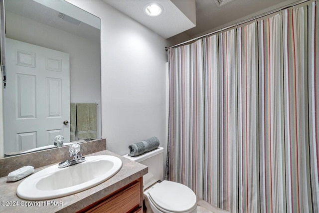 bathroom with a shower with shower curtain, vanity, and toilet