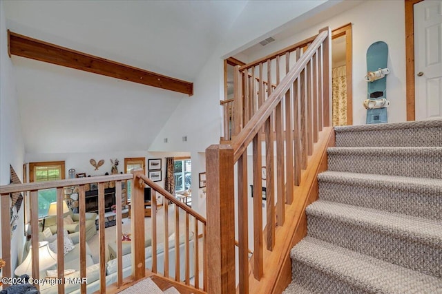 staircase featuring vaulted ceiling with beams, wood finished floors, and visible vents