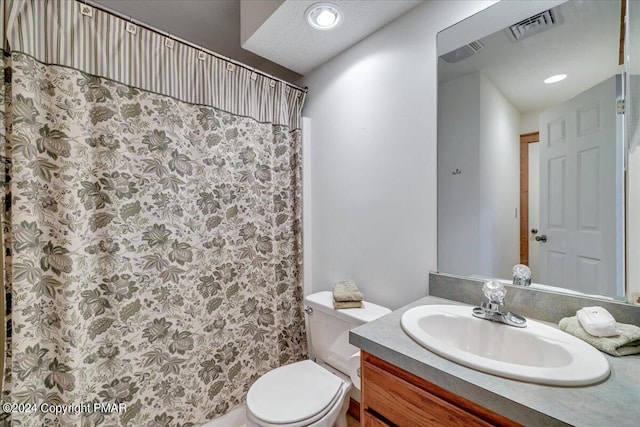 bathroom with toilet, vanity, visible vents, and recessed lighting