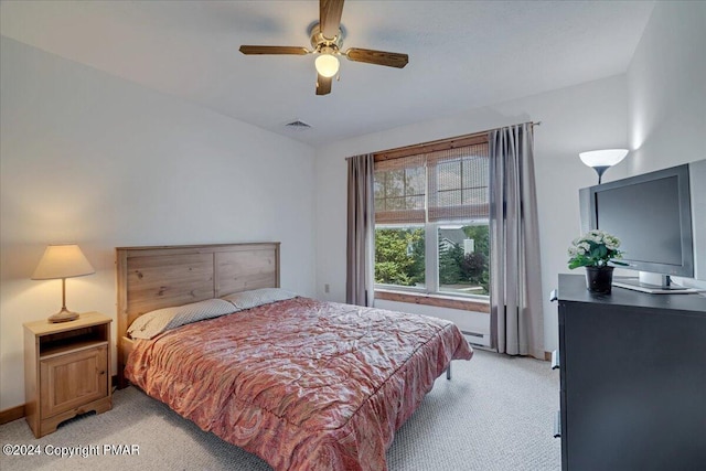 bedroom featuring light carpet, visible vents, a ceiling fan, baseboards, and baseboard heating