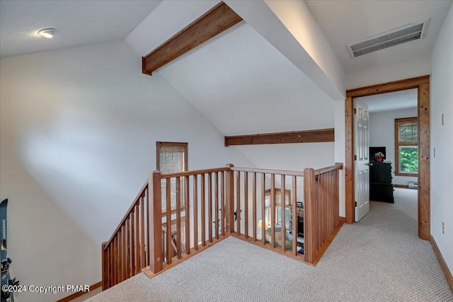 hallway with lofted ceiling with beams, carpet floors, an upstairs landing, visible vents, and baseboards