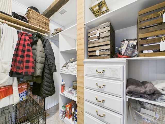 walk in closet with beam ceiling