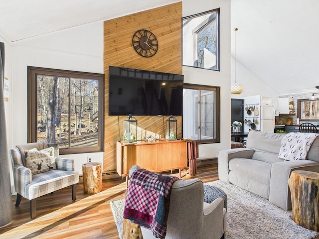 living room featuring high vaulted ceiling, wood walls, baseboard heating, and wood finished floors