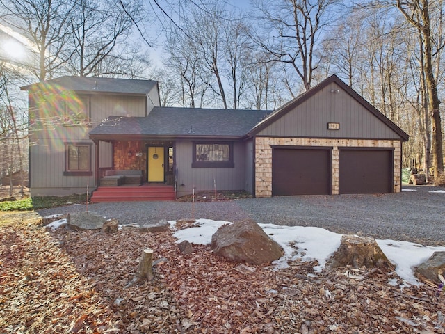 view of front of home featuring a garage, roof with shingles, and driveway