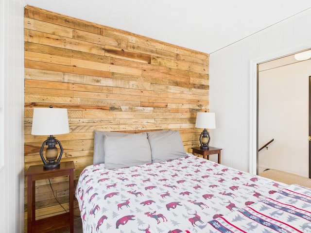 bedroom featuring wooden walls