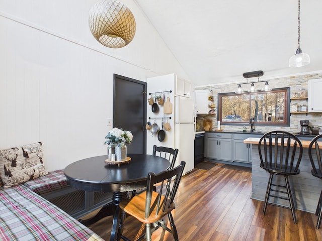 dining room featuring dark wood-style floors and vaulted ceiling