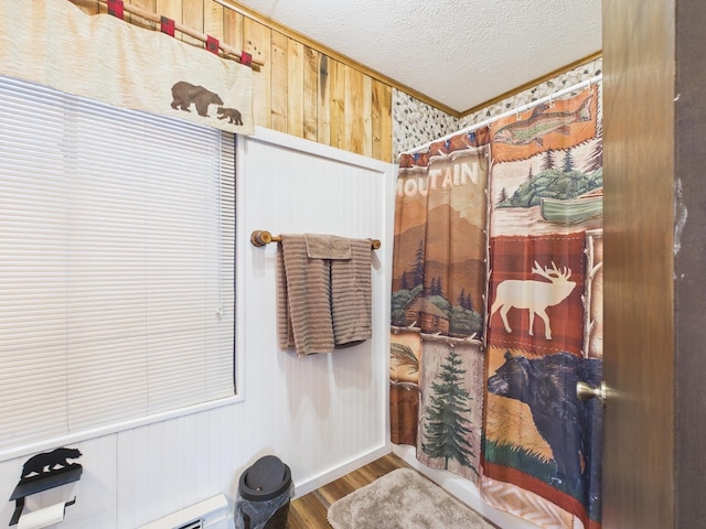 bathroom featuring a textured ceiling, a shower with shower curtain, and wood finished floors