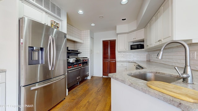 1220 Wyoming Ave, Forty Fort, PA 18704 - kitchen with light stone counters, a sink, white cabinets, tasteful backsplash, and appliances with stainless steel finishes
