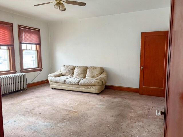 living room featuring radiator heating unit, baseboards, and a ceiling fan