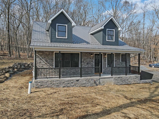 view of front of house with metal roof, stone siding, and a porch