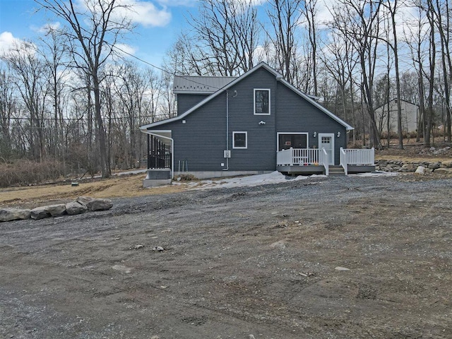 view of side of home with metal roof and a deck