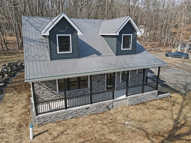 view of front facade featuring stone siding, metal roof, and a porch