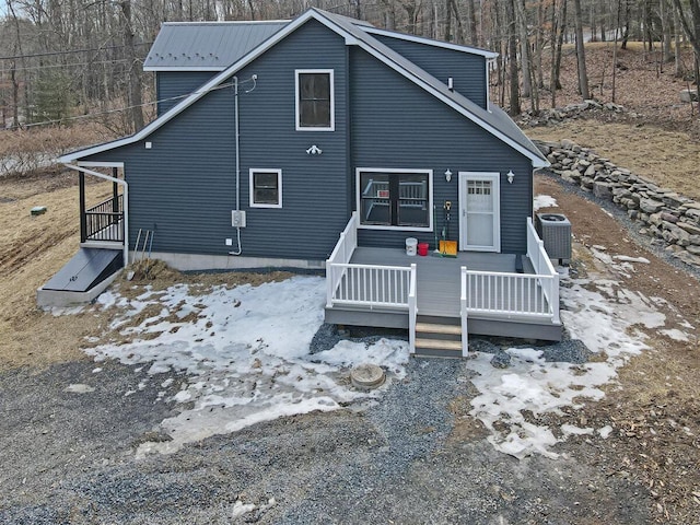 back of house featuring metal roof and central AC