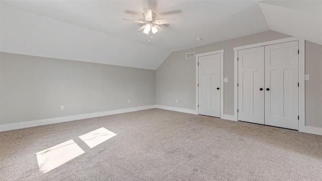 additional living space with lofted ceiling, visible vents, baseboards, a ceiling fan, and carpet