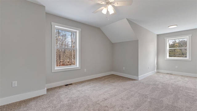 additional living space featuring carpet floors, visible vents, vaulted ceiling, ceiling fan, and baseboards