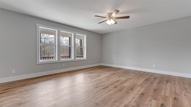 spare room with ceiling fan, light wood finished floors, and baseboards