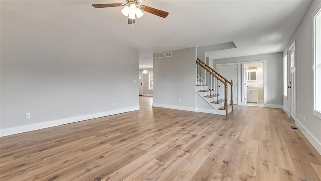 interior space featuring stairs, light wood finished floors, visible vents, and baseboards