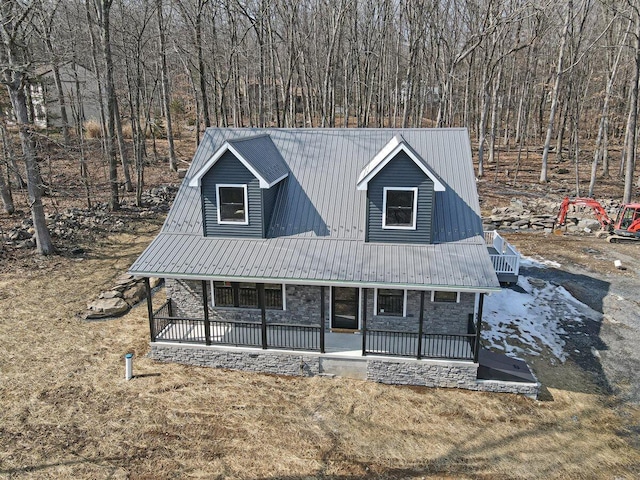 view of front of house with stone siding, metal roof, and a porch