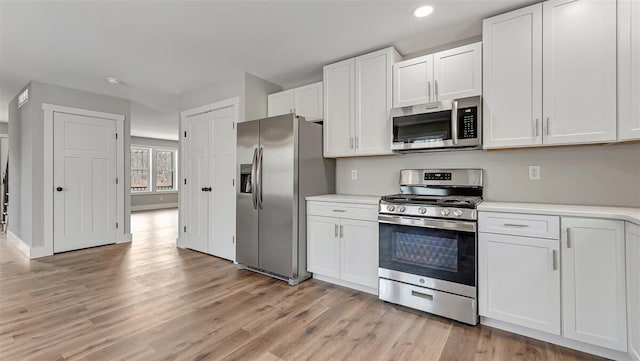 kitchen featuring recessed lighting, stainless steel appliances, light wood-style floors, white cabinets, and light countertops