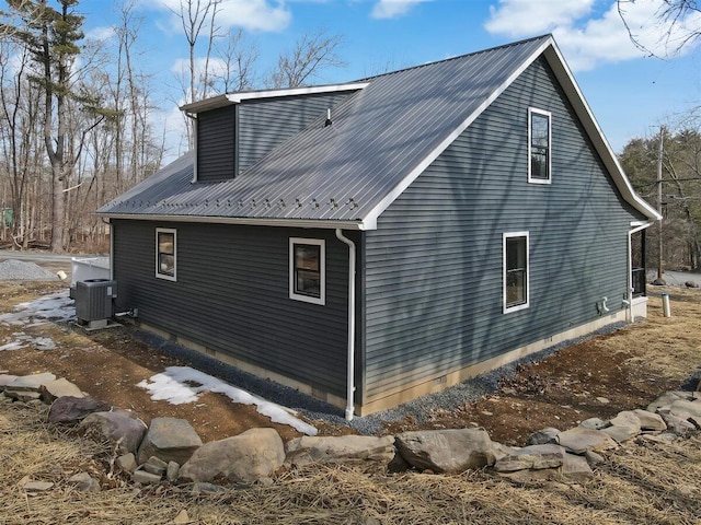 view of property exterior featuring metal roof and central air condition unit