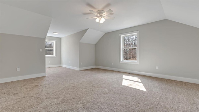 bonus room featuring carpet flooring, vaulted ceiling, baseboards, and ceiling fan