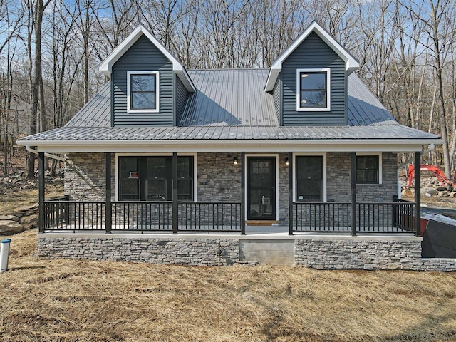 view of front of house featuring a porch, stone siding, and metal roof