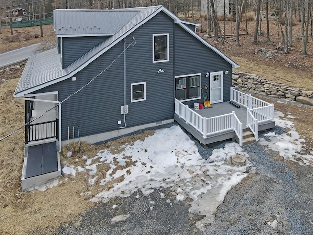 rear view of house featuring a deck and metal roof