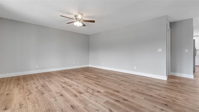 empty room featuring light wood-style flooring, a ceiling fan, and baseboards