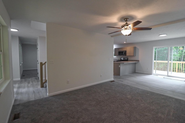 8305 Utopia Ln, East Stroudsburg, PA 18302 - unfurnished living room with light carpet, baseboards, ceiling fan, and light wood-type flooring