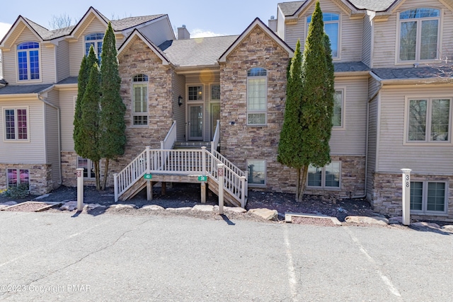 view of front of house featuring stone siding and a chimney