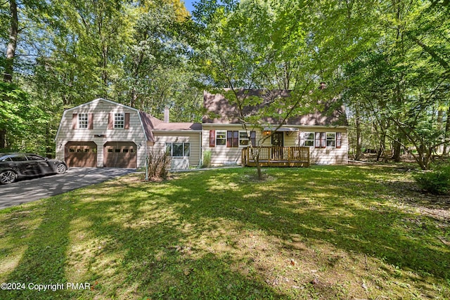 view of front of home featuring a front lawn, an attached garage, a gambrel roof, and aphalt driveway