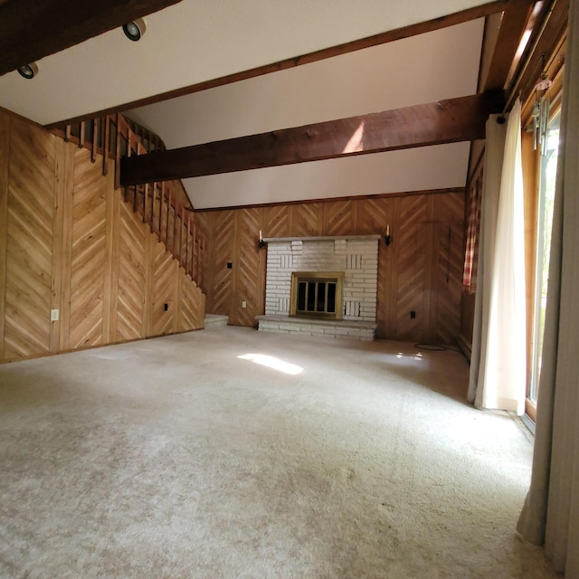 1119 Porter Dr, Bushkill, PA 18324 - unfurnished living room featuring wood walls, carpet floors, stairs, beamed ceiling, and a fireplace