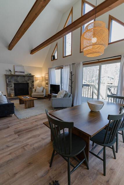 460 Maxatawny Dr, Pocono Lake, PA 18347 - dining room featuring a fireplace, high vaulted ceiling, light wood-style flooring, and beam ceiling