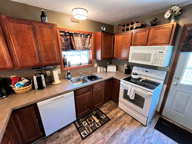 kitchen featuring a sink, a textured ceiling, decorative backsplash, and white appliances