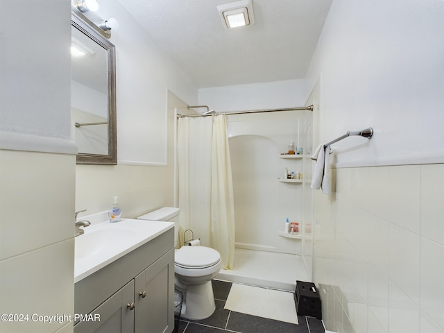 full bath featuring a textured ceiling, curtained shower, toilet, vanity, and tile patterned floors