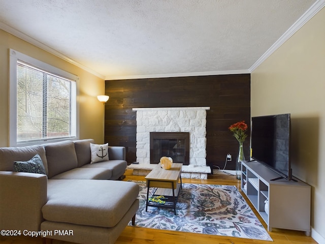 living room with wood walls, a textured ceiling, ornamental molding, and wood finished floors