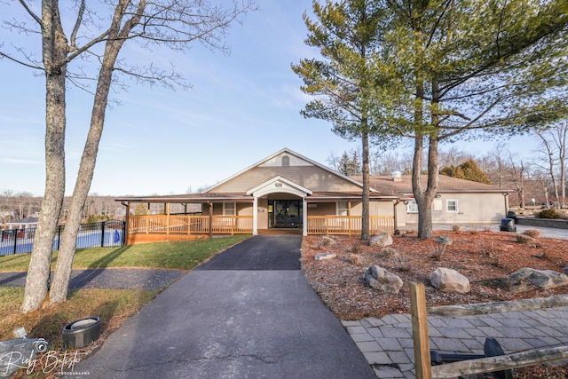 8066 Red Squirrel Dr, Tobyhanna, PA 18466 - view of front of property featuring covered porch, fence, a front yard, and aphalt driveway
