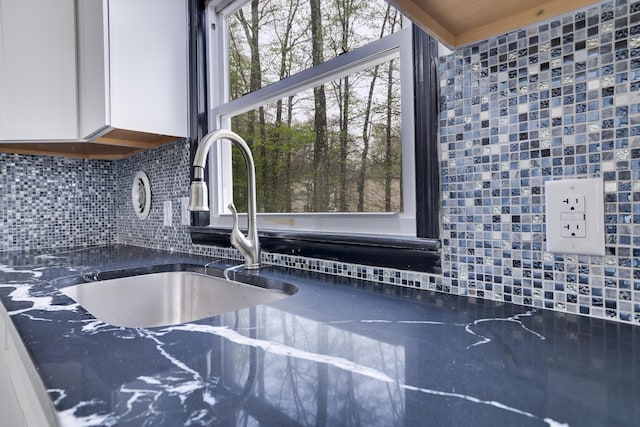 8066 Red Squirrel Dr, Tobyhanna, PA 18466 - details with backsplash, white cabinets, dark stone countertops, and a sink