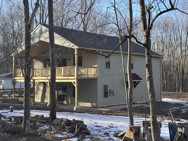 snow covered property featuring a shingled roof