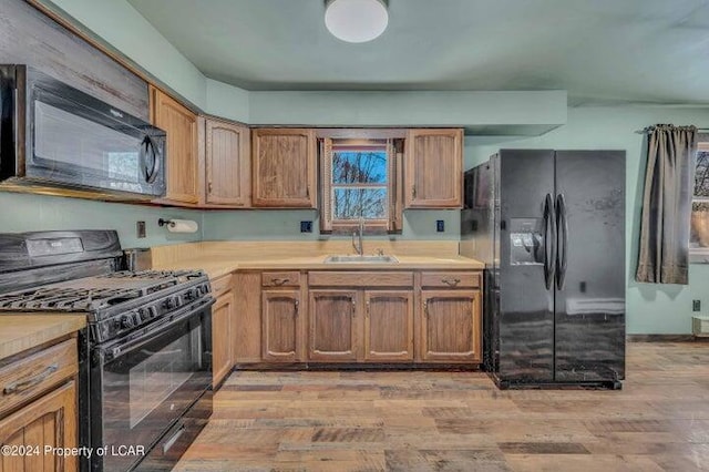 8 Tulip Ln, Thornhurst, PA 18424 - kitchen with black appliances, light countertops, light wood-type flooring, and brown cabinetry
