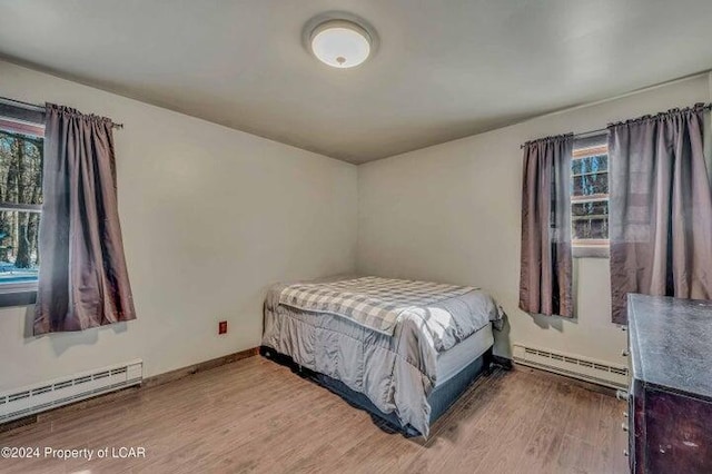 8 Tulip Ln, Thornhurst, PA 18424 - bedroom with baseboard heating, multiple windows, and wood finished floors