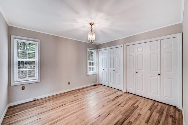 14 Ace Ln, East Stroudsburg, PA 18301 - unfurnished bedroom with wood finished floors, two closets, crown molding, a chandelier, and baseboards