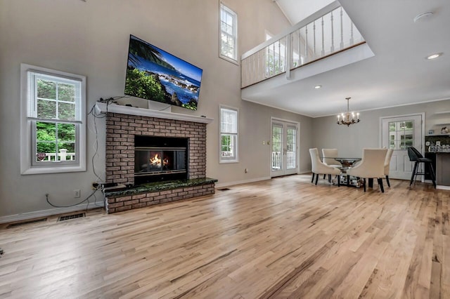 14 Ace Ln, East Stroudsburg, PA 18301 - living area featuring wood finished floors, a chandelier, a high ceiling, a brick fireplace, and baseboards